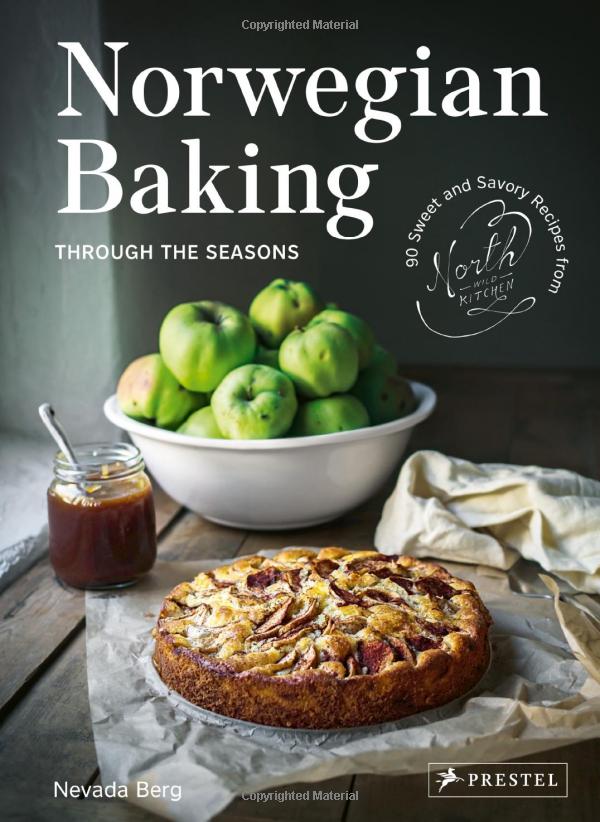 Front cover of cookbook "Norwegian Baking". Pictured is a white bowl with green apples and homemade cake from recipe inside. 