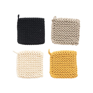 Individually displayed warm color collection of crocheted pot holders. Black, taupe, cream, and yellow ochre. 