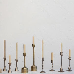 Coordinating and contrasting hammered gold candle taper holders in varying styles and sizes. 