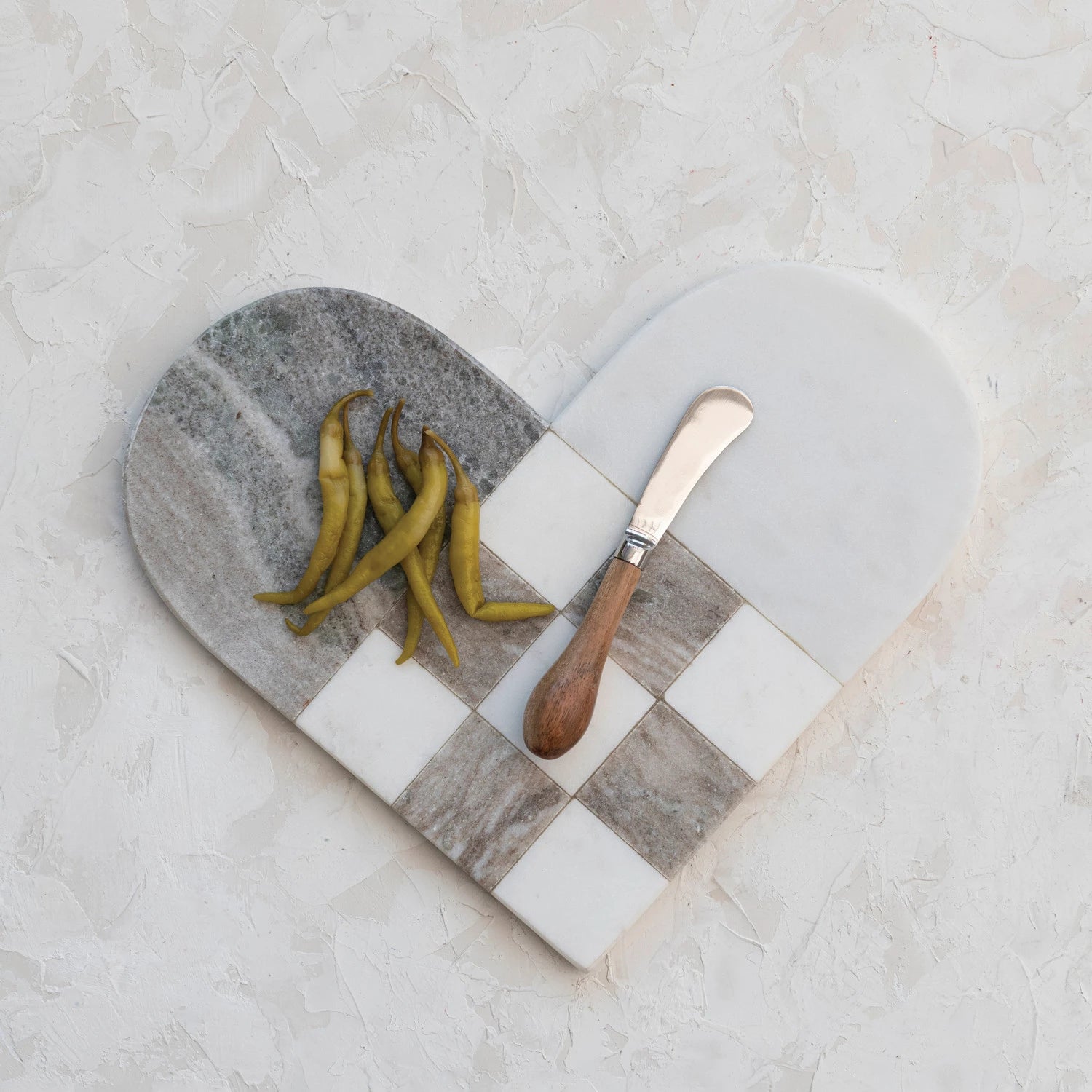Two-toned white and grey marble cutting board in the shape of a heart with a charcuterie knife included. 