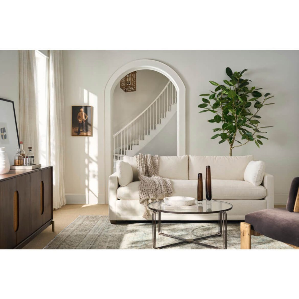 Modern living room with a white sofa, coffee table, and decorative items.
