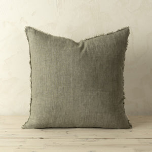 Gray linen pillow with frayed edges on a wooden surface and beige wall background. Down feather filled 20x20.