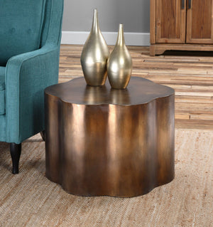 Copper side table with a waved pattern featured in a living room.