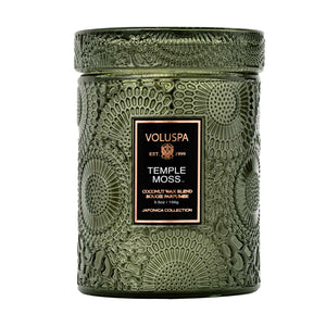 5.5 ounce green embossed Voluspa candle with 'Temple Moss' label on a white background.