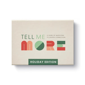 The box for 'Tell Me More: Holiday Edition' card game, featuring a beige background with colorful geometric lettering and a green banner at the bottom.