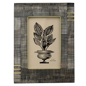 Decorative 4x6 inch photo frame made of acacia wood, horn, and brass in visually unique pattern. Plant illustration graphic in center. 