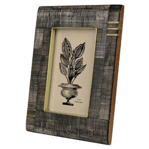 Side view of a decorative 4x6 inch photo frame made of acacia wood, horn, and brass in visually unique pattern. Plant illustration graphic in center. 