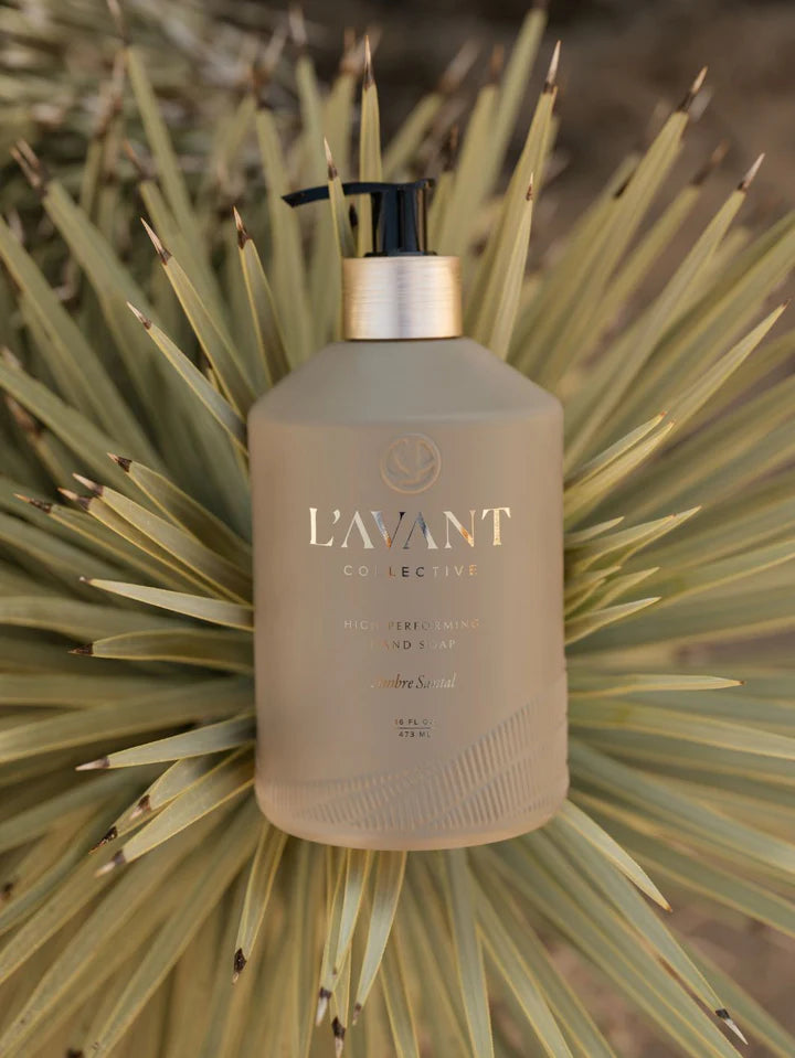 L'AVANT Collective beige bottle on a natural cactus background. Ambre Santal. 
