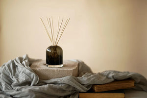 Decorative diffuser with reeds on a stone surface with a soft background