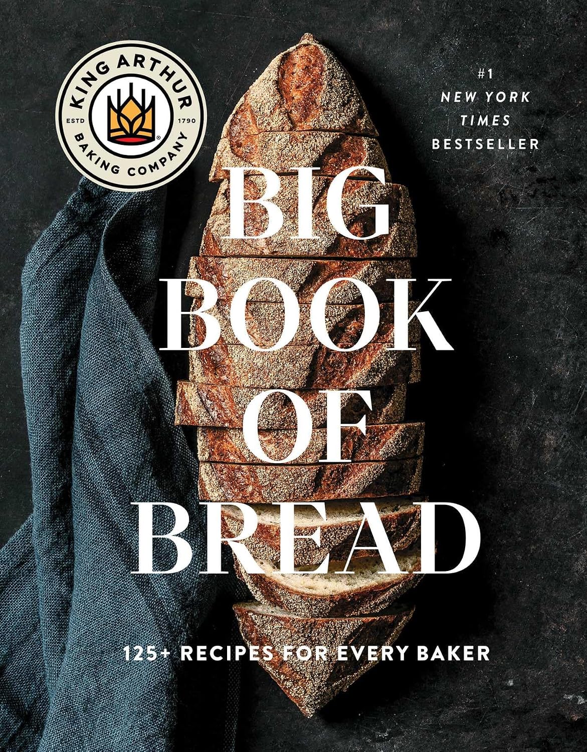 Book cover of 'Big Book of Bread' by King Arthur Baking Company with bread slices and a blue towel on a dark background.