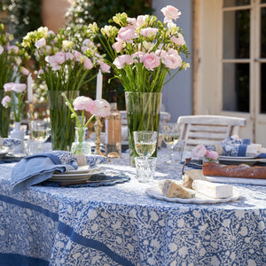 Outdoor table setting with floral arrangements and blue and white floral printed tablecloth. Couleur Nature. 