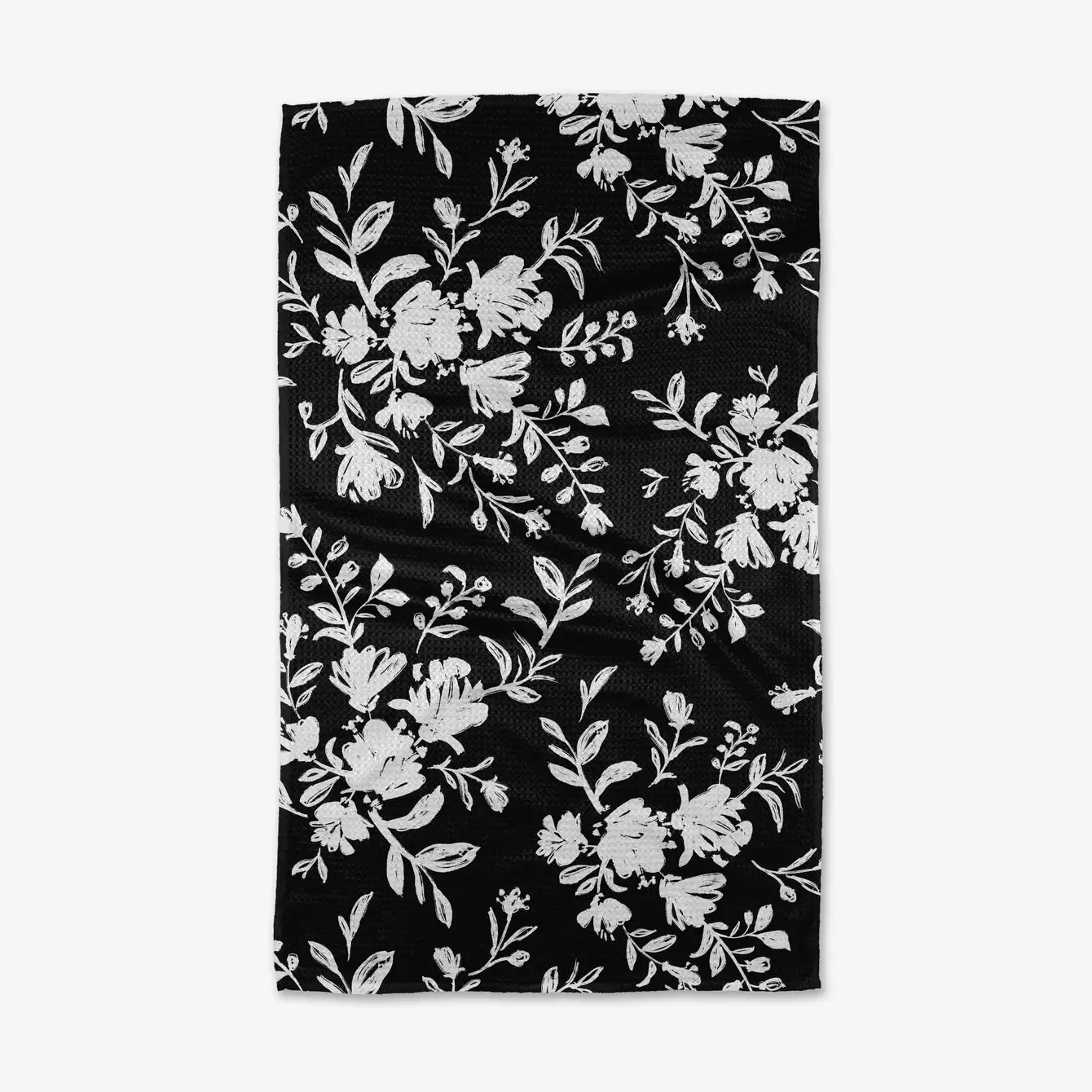 Black and white tea towel with floral pattern on a white background. Geometry House.