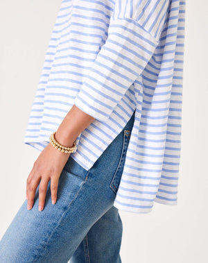 Person wearing a blue and white striped shirt and jeans on a light background