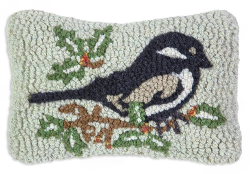 Decorative wool pillow with a bird and branch design on a light background.