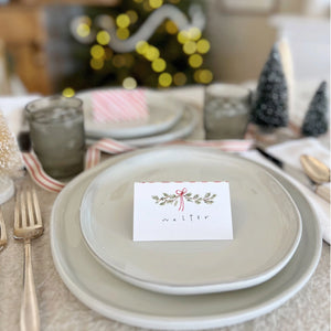 Christmas-themed table setting with a name card on a plate. Emily Lex Studios. 