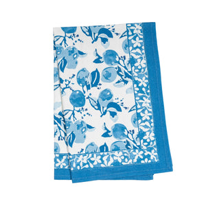 Blue floral and fruit patterned tea towel on a white background.