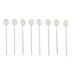 Eight clear faceted round cocktail picks with silver metal stems, arranged in a row on a white background. Gem Picks. 
