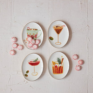 Set of four holiday cocktail appetizer plates with different individual beverage designs. Candy mints displayed on the plates. 