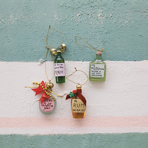 Decorative bottle ornaments with humorous labels on a striped background