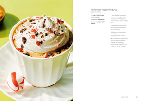 A two-page recipe spread for Homemade Peppermint Syrup. The left page features a close-up photograph of a whipped cream hot chocolate topped with crushed candy canes and peppermint pieces, served on a white saucer.