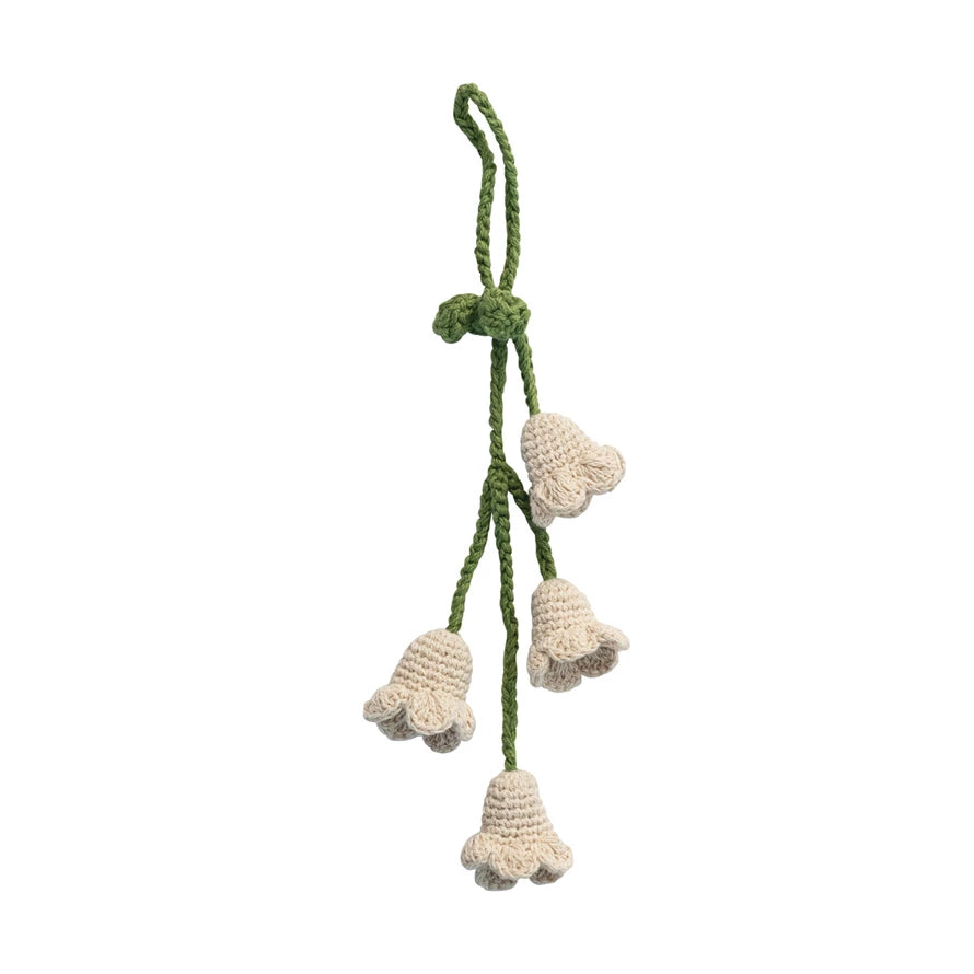Crocheted flower door hanger decoration with green stem on against white background. 