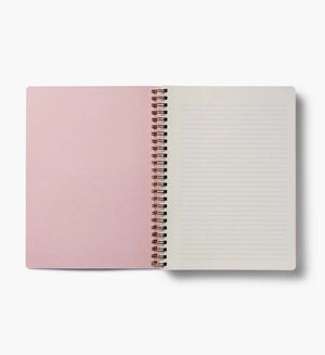 Open spiral-bound notebook with pink cover and white pages on a white background. Rifle Paper Co. 