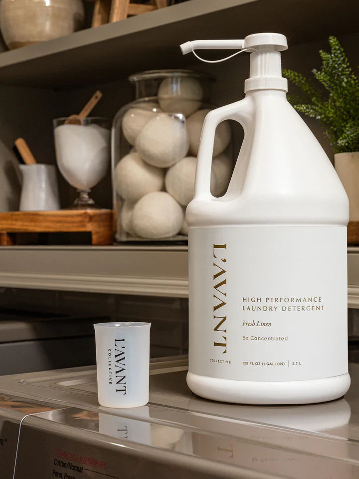 Lavant laundry detergent bottle on a kitchen counter with a small measuring cup for the product.