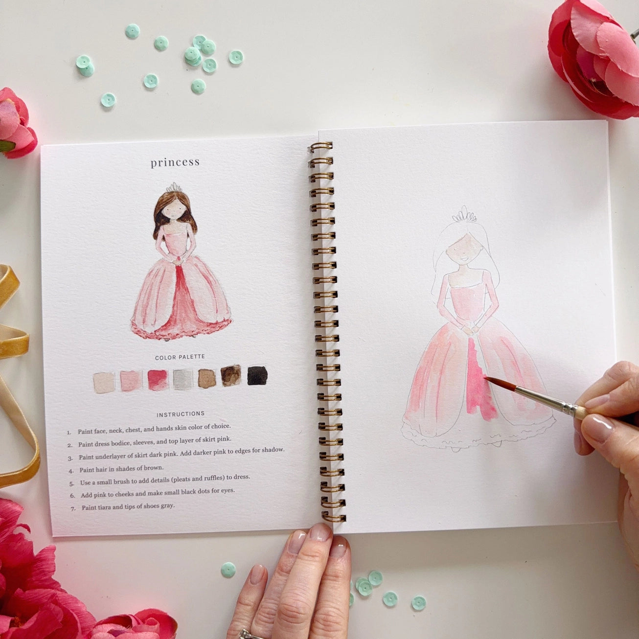 Person painting illustrations of a princess with color palette instructions, surrounded by decorative floral elements. Emily Lex Studios. 