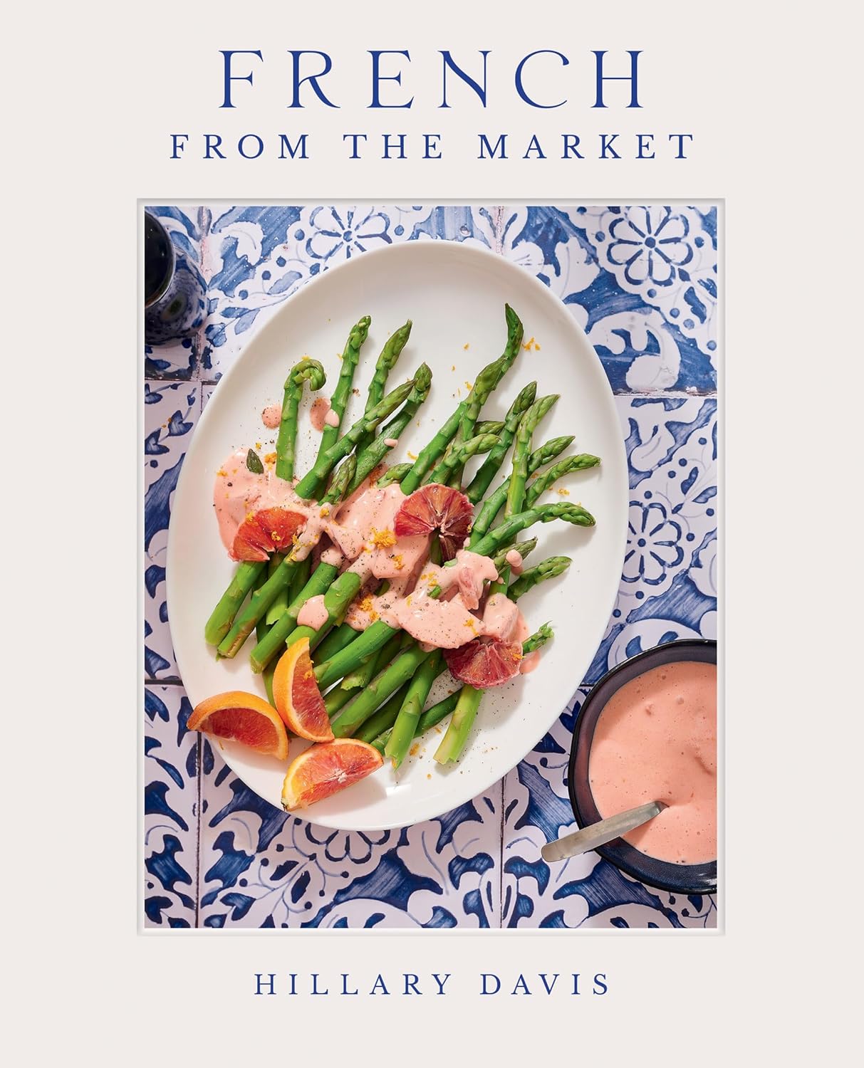 Front cover of "French from the market" . Recipe of asparagus dish displayed on ceramic plate. French tile background. 