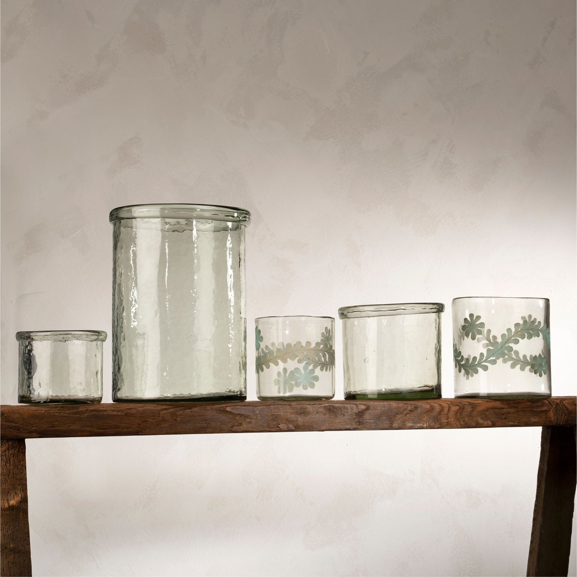 Recycled hand blown glass hurricane vases in coordinating sizes of small, medium, and large. 