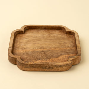 A square wooden tray with rounded corners and a carved decorative edge, shown on a plain light beige background.