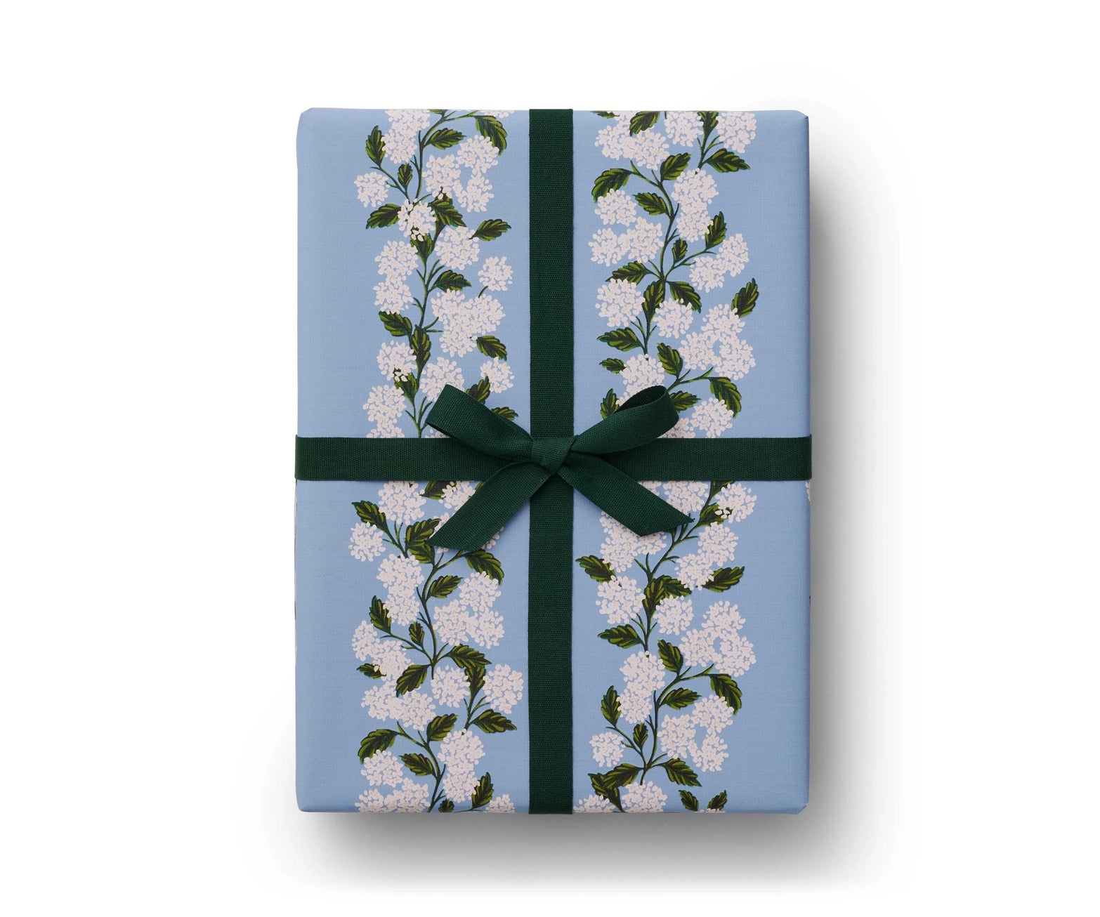 Gift box wrapped with white hydrangea floral light blue design gift wrapping; green velvet ribbon tied in finishing bow on top. Rifle Paper Co. 