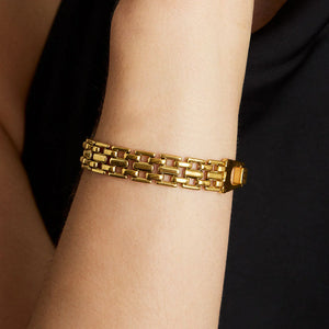 Mara gold chain link bracelet on a wrist with a black background. Dean Davidson jewelry