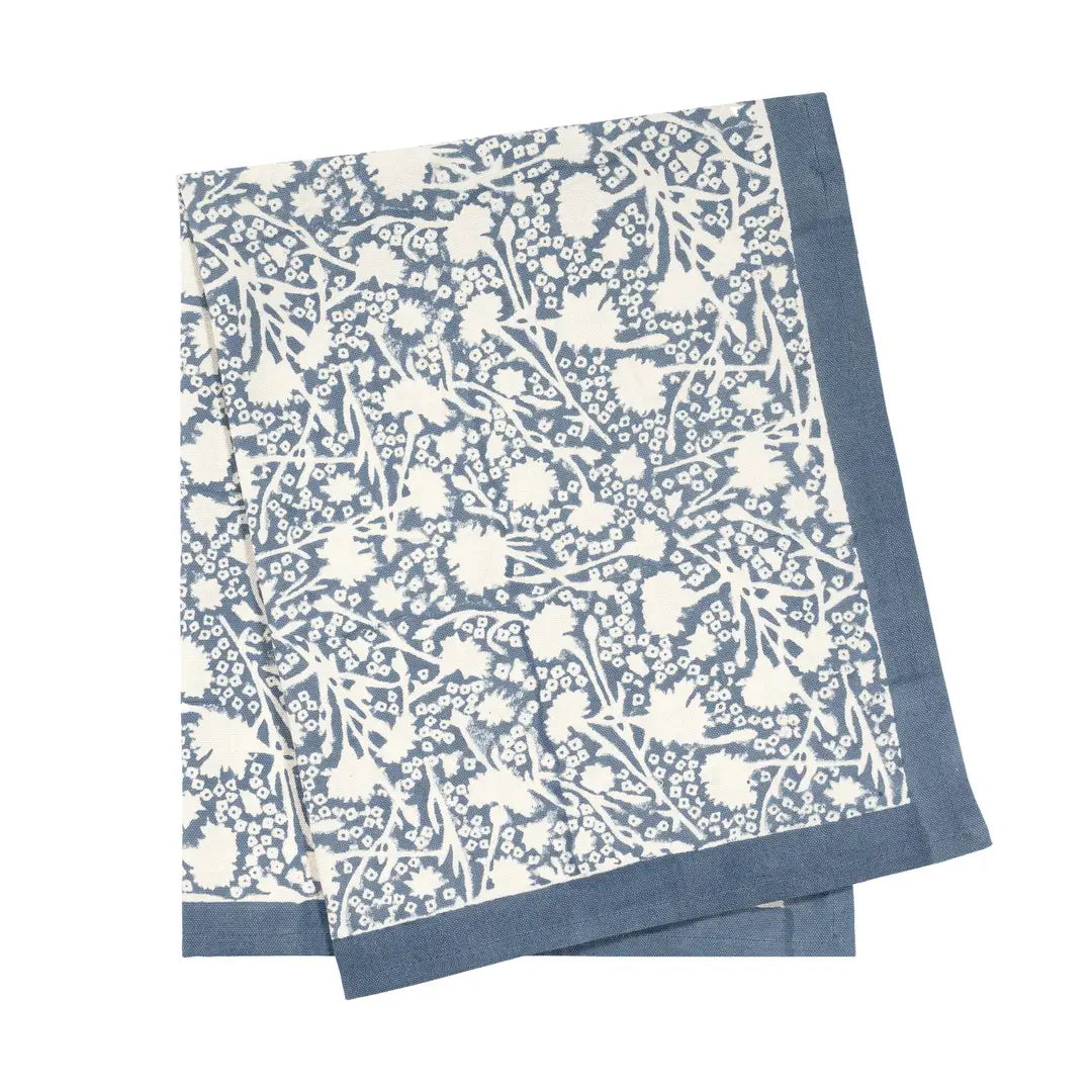 Blue and white provencal floral patterned tea towel on a white background.