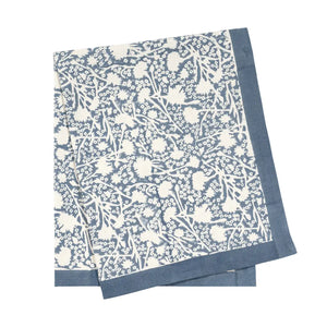 Blue and white provencal floral patterned tea towel on a white background.