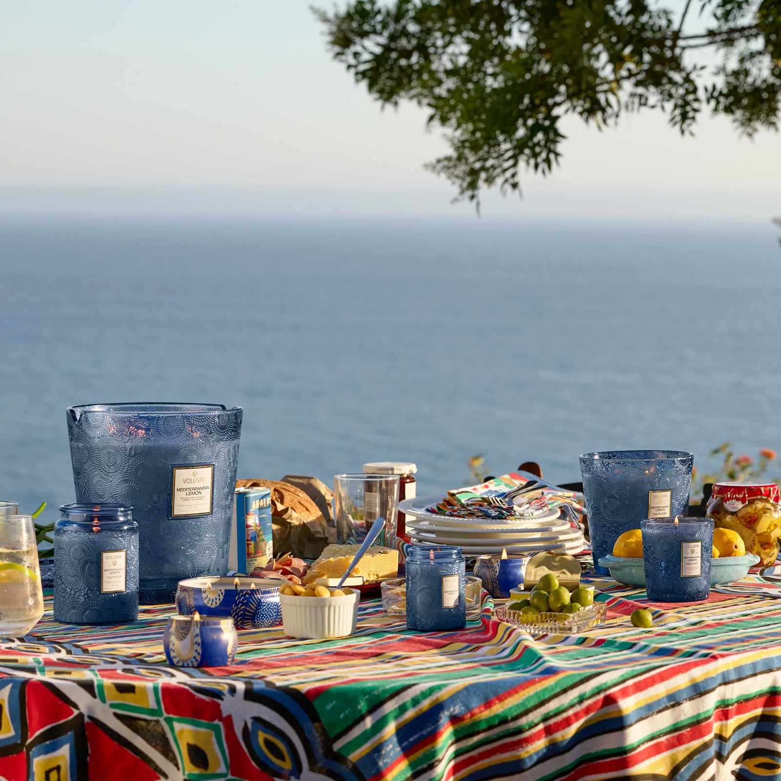 NEW! Mediterranean Lemon home candle line with room & body spray displayed across sea side tablescape. Voluspa. 