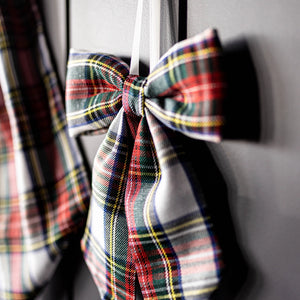 Small sized holiday plaid hanging bow with close up detail of the colors and texture. 