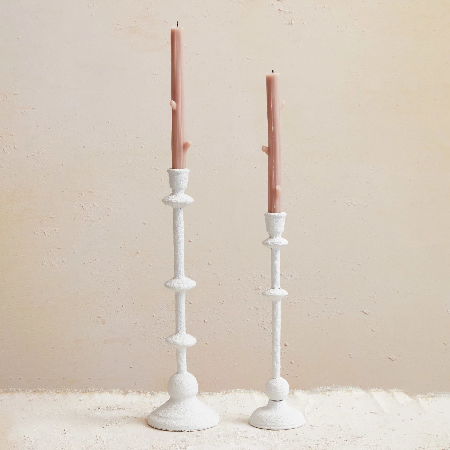 Large and medium sanded white textural candle taper holder with pink candle. 