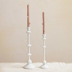 Large and medium sanded white textural candle taper holder with pink candle. 