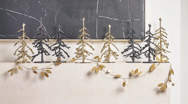 Holiday fireplace mantel decorated with various metal trees and gold leaf designed metal garlands. 