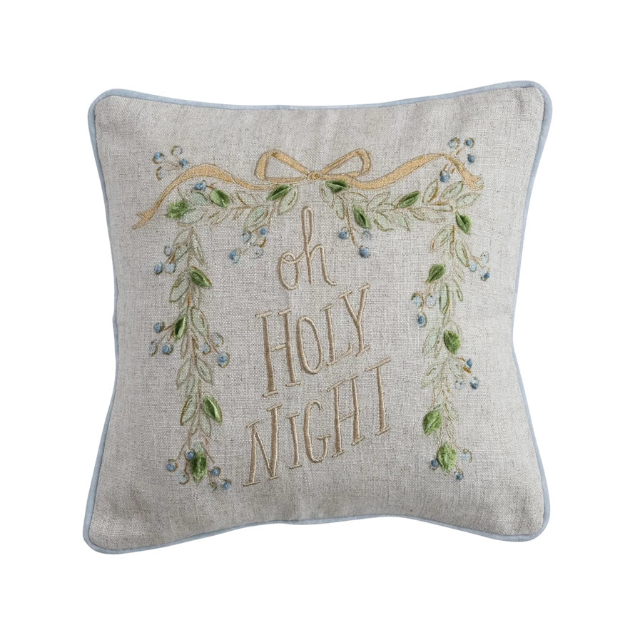 Decorative Christmas pillow with 'oh holy night' embroidery, garland, and bow on a light linen and cotton fabric. Baby blue velvet trim. 