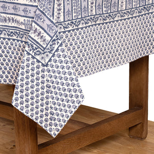 Blue and white French Provence floral patterned tablecloth on a wooden table.