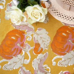 Detailed top view of patterned orange and mustard yellow pumpkin tea towels. 