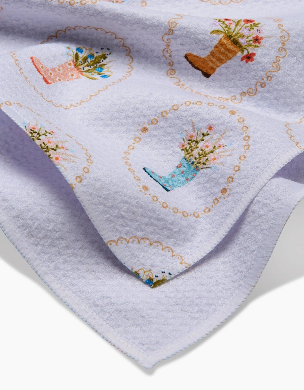 White tea towel with rainboots in bloom with floral patterns. Geometry tea towels. 