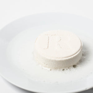 Individual "recover" shower steamer from Bathorium displayed on a plate. 