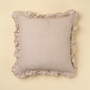 Striped linen and cotton pillow with ruffled edges on a beige background