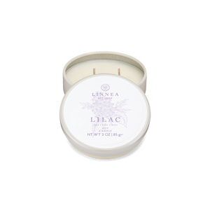 Candle in a white tin with 'Linnea' branding on a white background