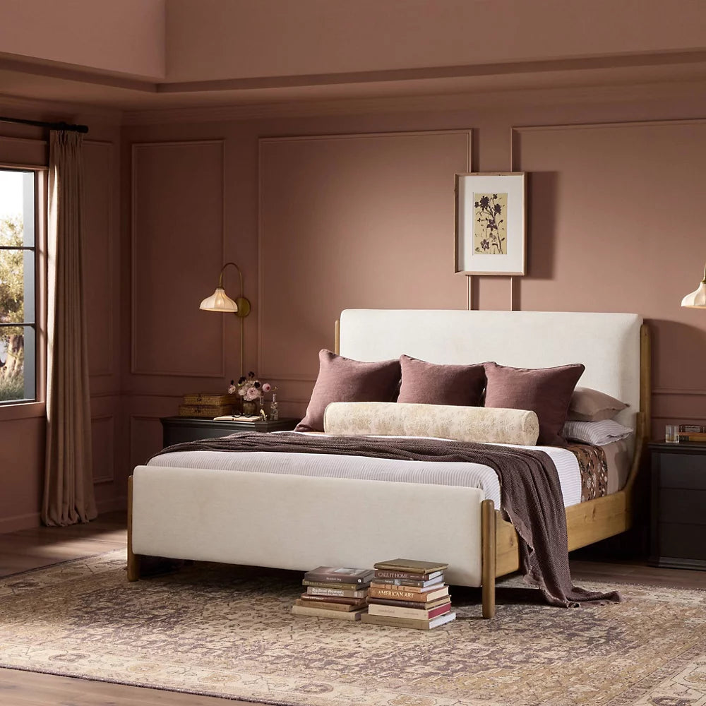 Neatly made bed with decorative pillows in a bedroom setting.