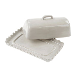 Scalloped white ceramic butter dish with lid open on a white background. 