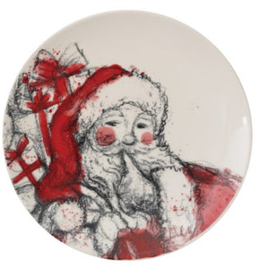 A round white ceramic plate featuring a whimsical, sketch-style illustration of Santa Claus with a red hat, white beard, and red coat, alongside wrapped presents with red bows.